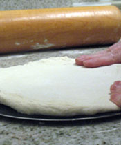 Use your fingers to stretch and shape the dough
